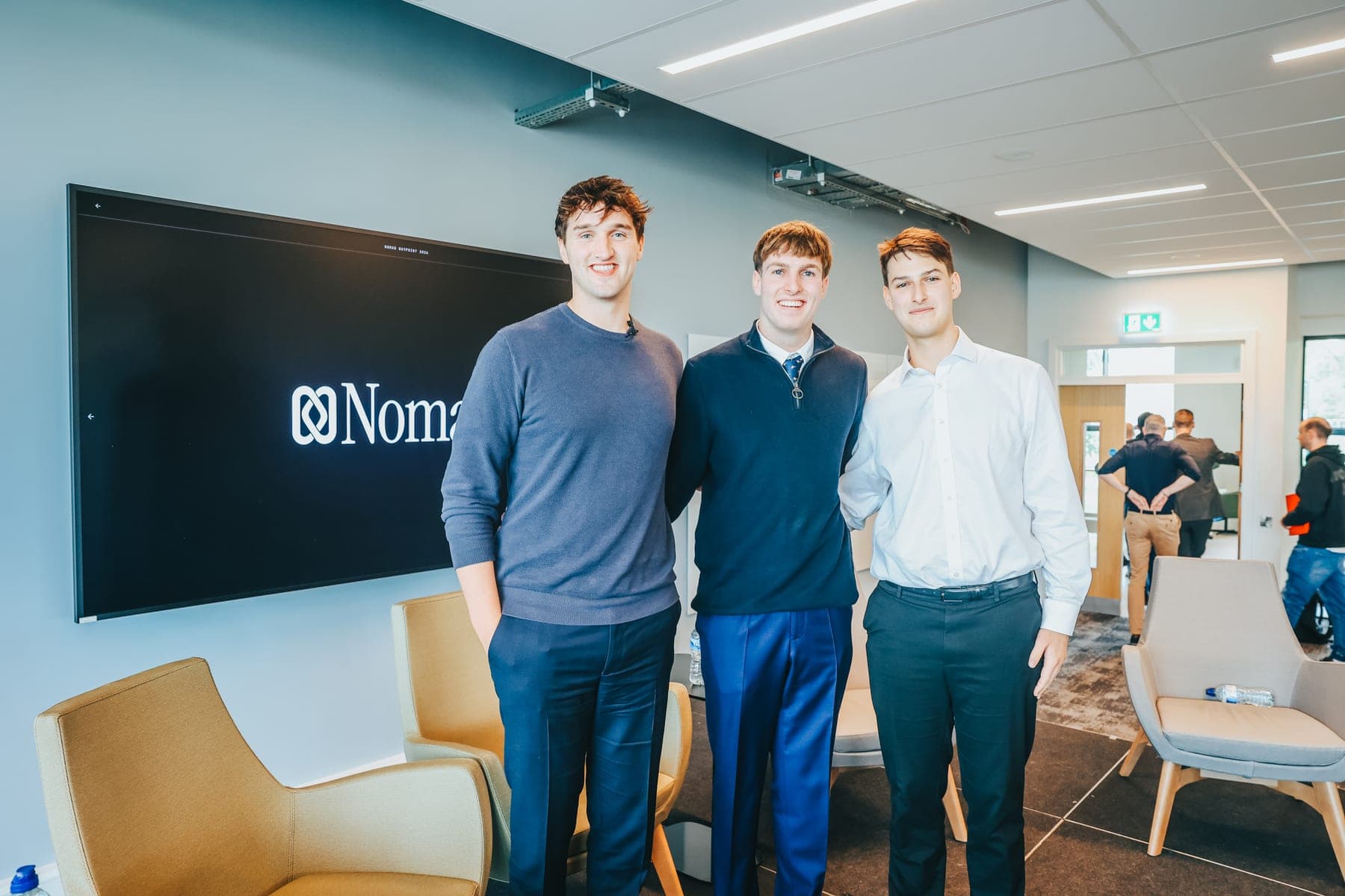 Three of the Nomad team in the room at Waypoint, in front of the stage screen.